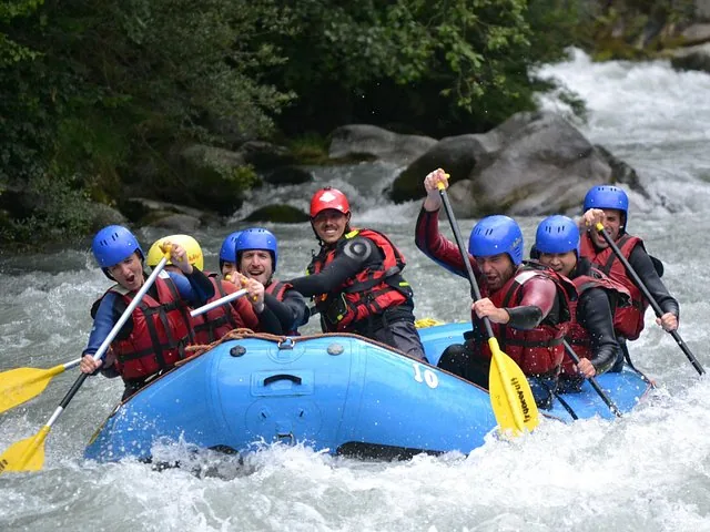 Group of people white water rafting on a river near Monte Bianco