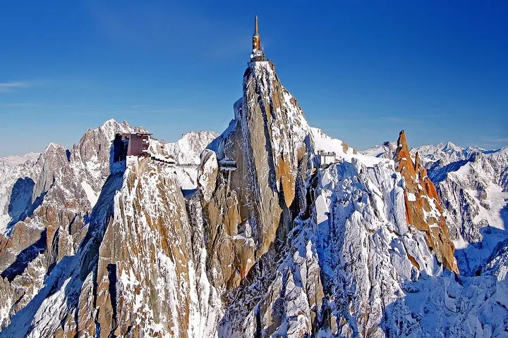 Aiguille du Midi peak with buildings on top covered in snow