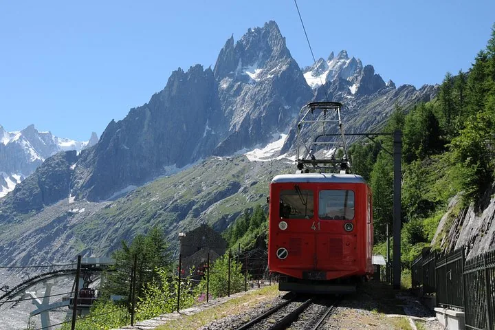 Red mountain train traveling near Monte Bianco with peaks in background