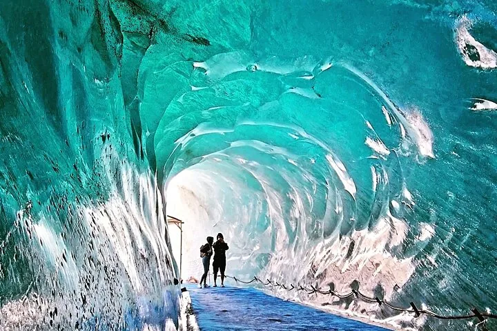 Two people exploring an ice cave near Monte Bianco